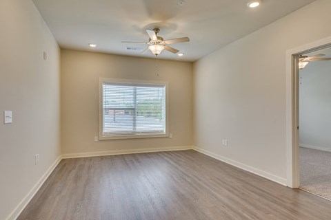 an empty living room with a ceiling fan at The Augustan, Augusta, Georgia