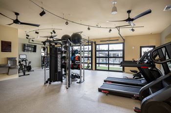 a gym with treadmills and other exercise equipment and a window at The Augustan, Augusta