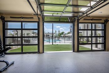 the view of the pool from inside an empty gym with glass doors at The Augustan, Georgia