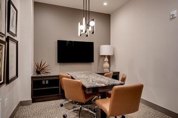 a conference room with a table and chairs and a tv at The Augustan, Augusta, 30901