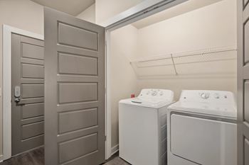 a laundry room with a washer and dryer and a closet with a door at The Augustan, Augusta, Georgia