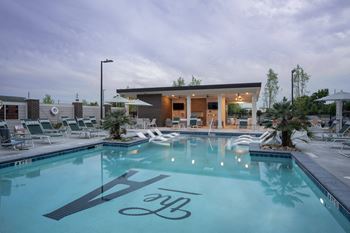 a swimming pool with lounge chairs and a building with a pool at The Augustan, Augusta, 30901