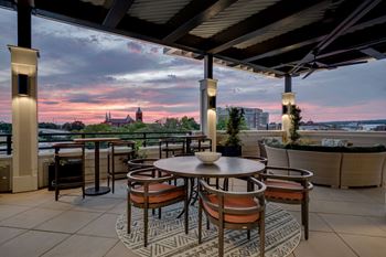 a terrace with tables and chairs overlooking a city at sunset at The Augustan, Augusta