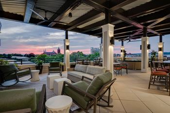 a patio with couches and chairs and a view of the river and a building at The Augustan, Georgia, 30901