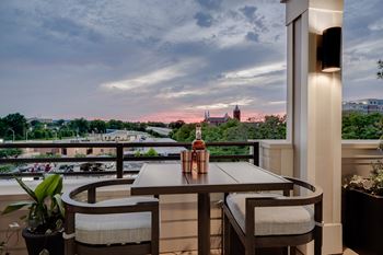 a balcony with a table and chairs and a bottle of wine on it at The Augustan, Georgia
