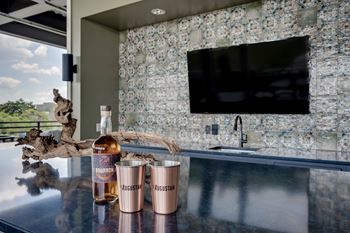 a bar with two glasses and a bottle of whiskey on it at The Augustan, Augusta, 30901