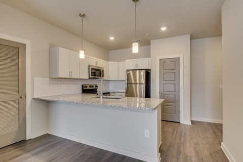 a kitchen with white cabinets and a granite counter top at The Augustan, Georgia