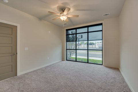 an empty bedroom with a large window and a ceiling fan at The Augustan, Augusta