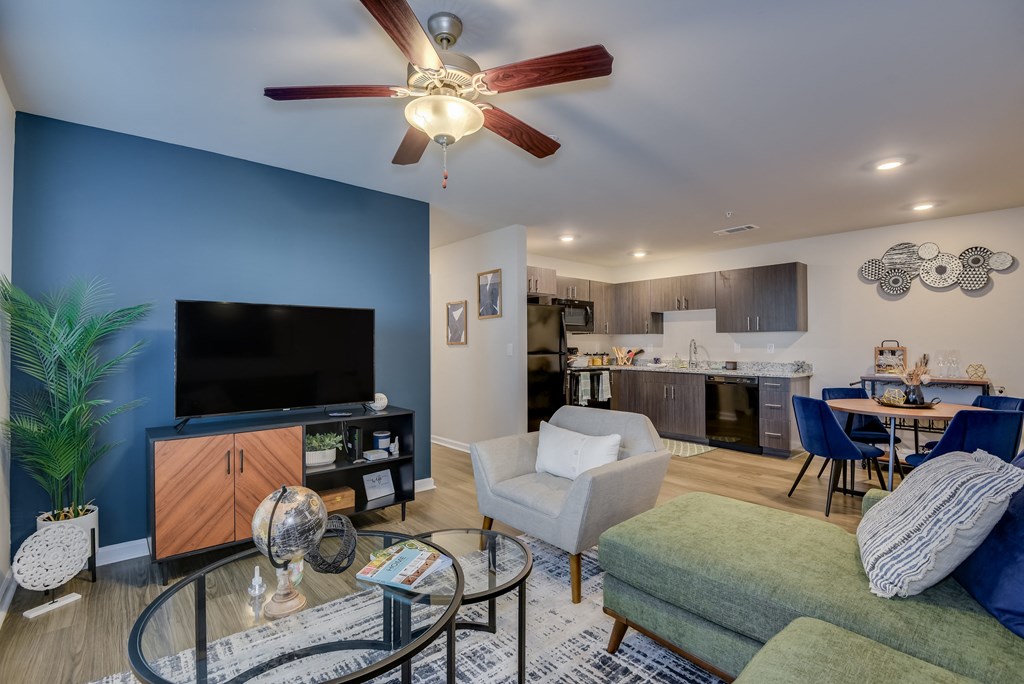 a living room with a blue accent wall and a ceiling fan