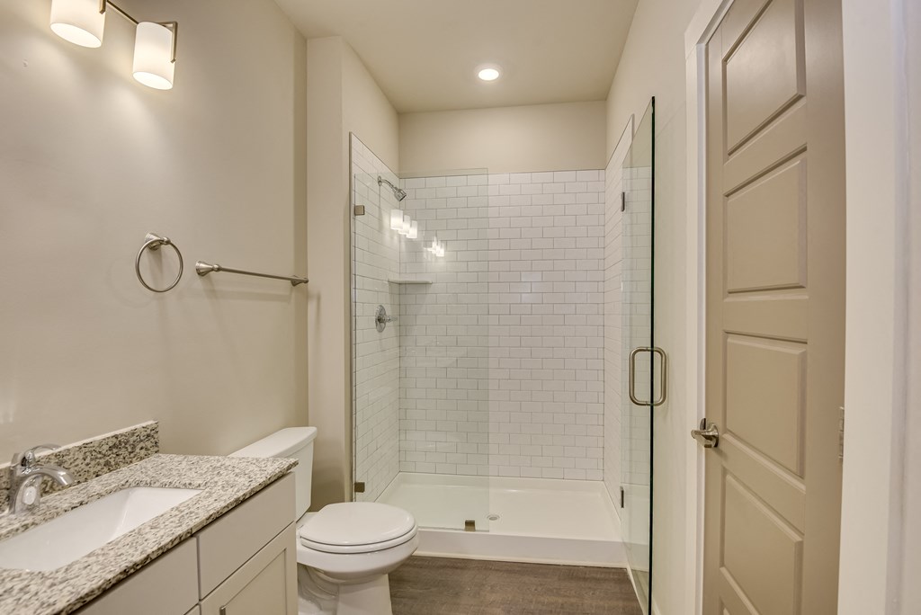 a bathroom with a shower and a sink and a toilet