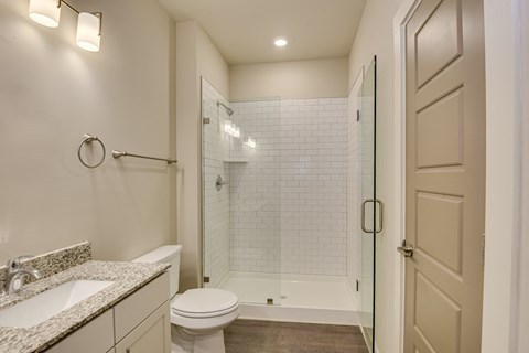 a bathroom with a shower and a sink and a toilet at The Augustan, Augusta, GA