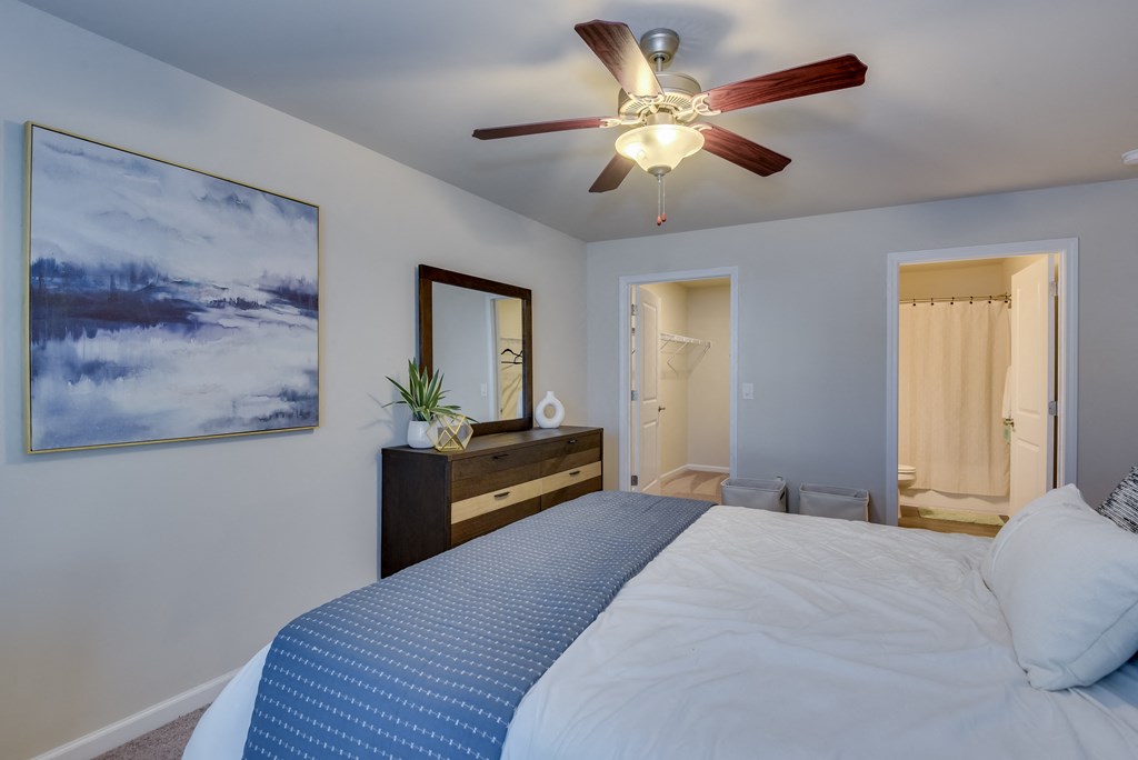 a bedroom with a large bed and a ceiling fan