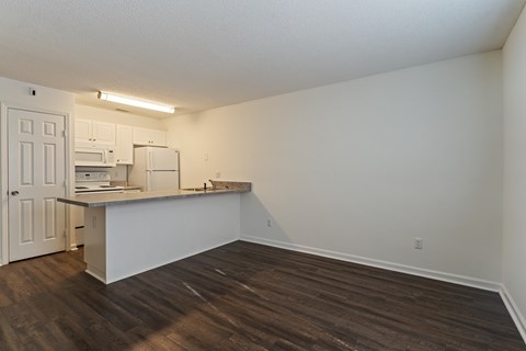 A kitchen with white cabinets and a white fridge is shown.