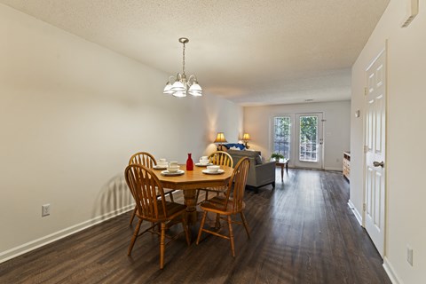 A dining room with a wooden table and chairs.