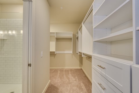 a walk in closet with white cabinets and a tiled floor at The Augustan, Augusta, 30901