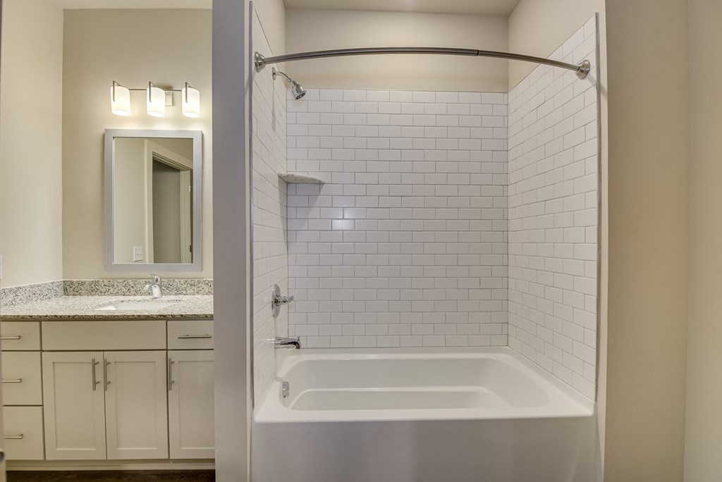 a bathroom with a tub and a sink and a mirror