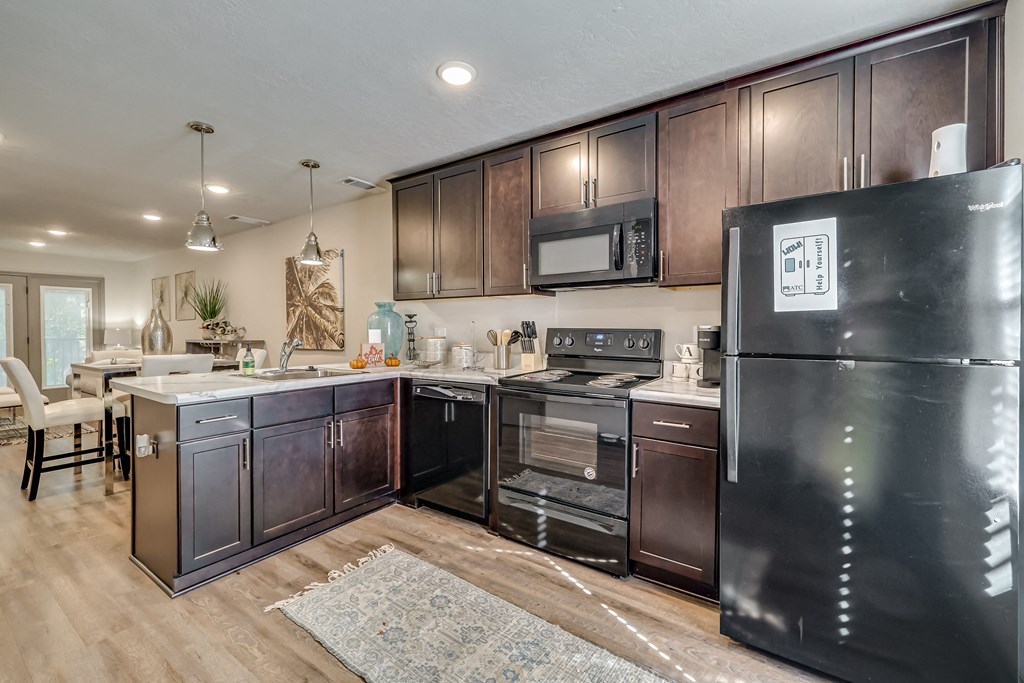 Kitchen with cherry wood cabinets and black appliances at Forest Hills Racquet Club, Augusta