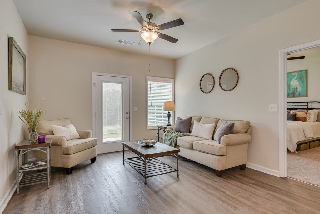 a living room with a ceiling fan and two couches