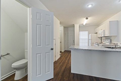 A white door is open to a kitchen.