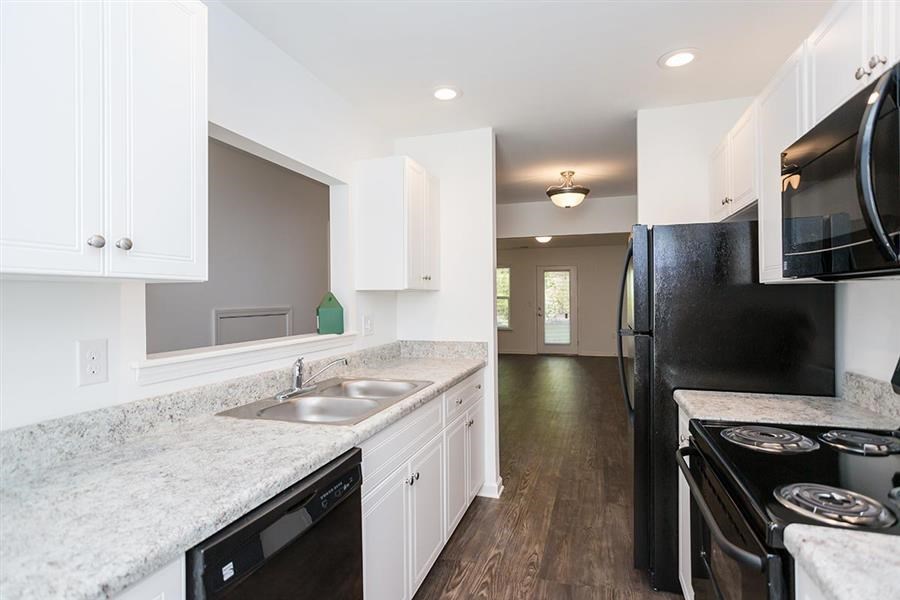 a kitchen with a sink and a black refrigerator