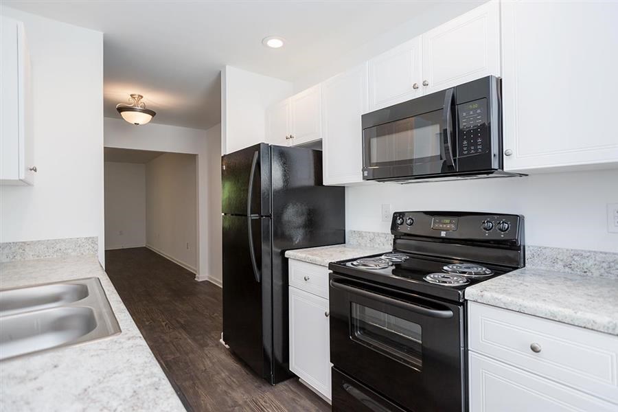 a kitchen with a stove refrigerator and a microwave
