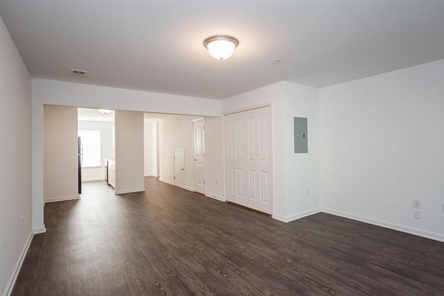an empty living room with white walls and wood floors