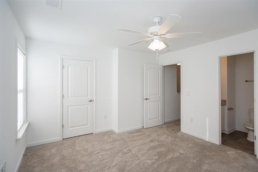an empty living room with a ceiling fan