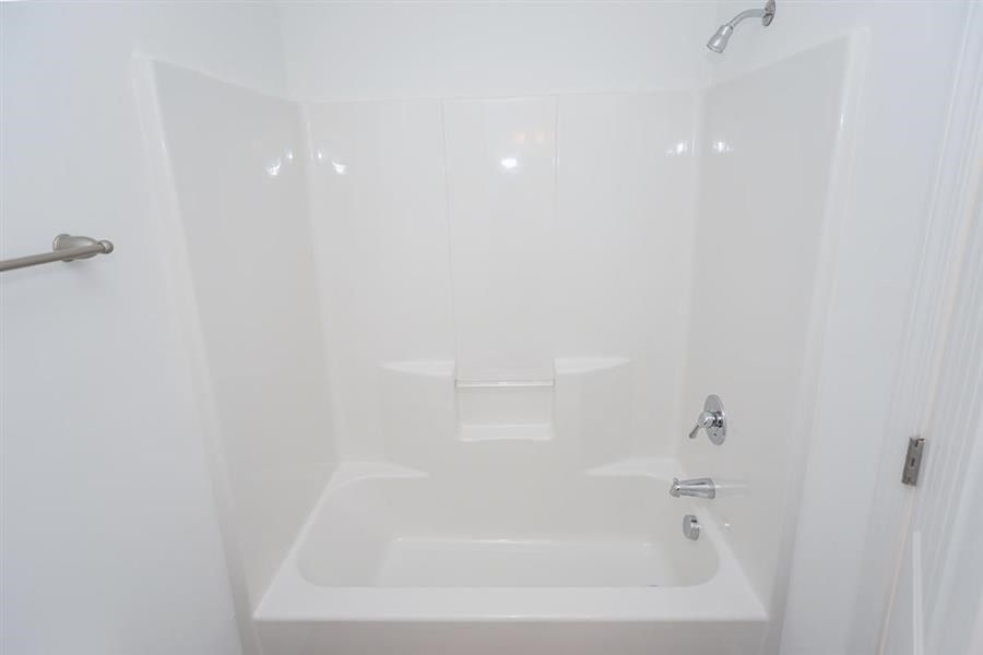a white bathroom with a shower and a sink