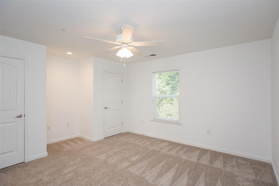 a white room with a ceiling fan and a window