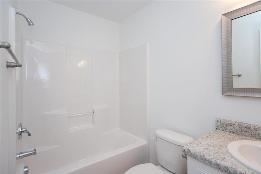 a white bathroom with a sink toilet and shower