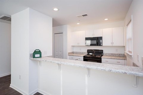 a kitchen with white cabinets and a counter top