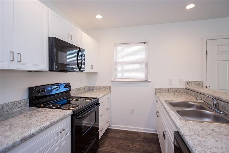 a kitchen with a stove microwave and sink