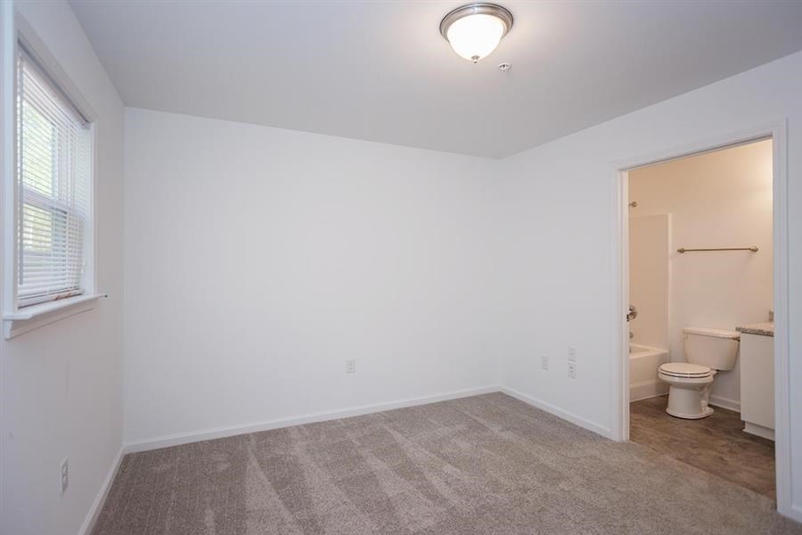 an empty room with a toilet and a window