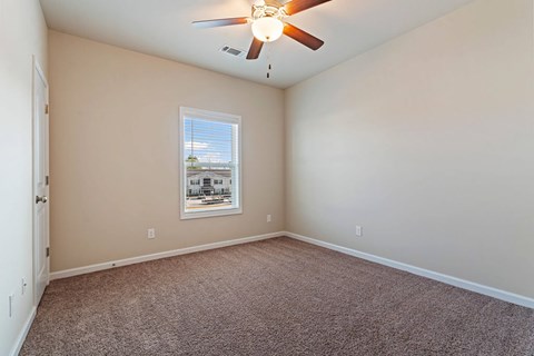 A room with a ceiling fan and a window.