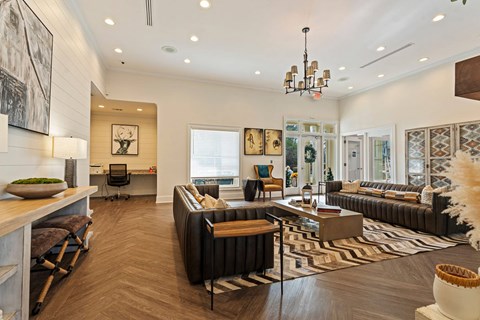 A living room with a black couch and a wooden coffee table.