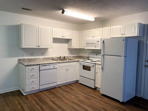 a kitchen with white cabinets and a refrigerator