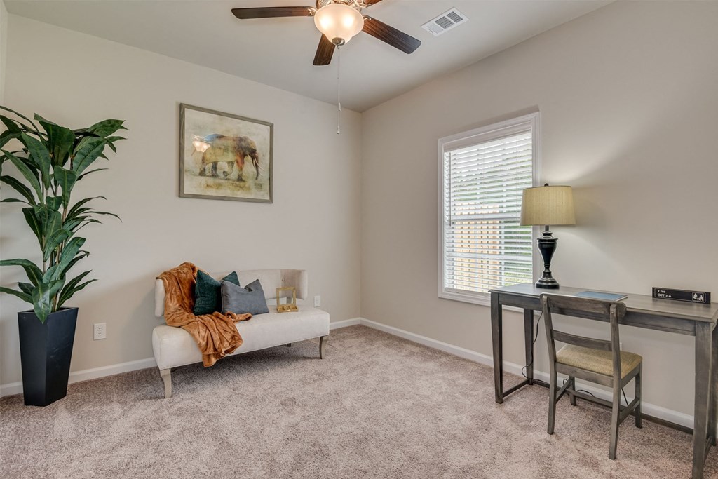 a living room with a couch and a table and a ceiling fan