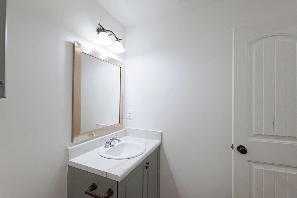Bathroom with framed mirror and vanity lighting at Sterlington Apartments, Grovetown, GA