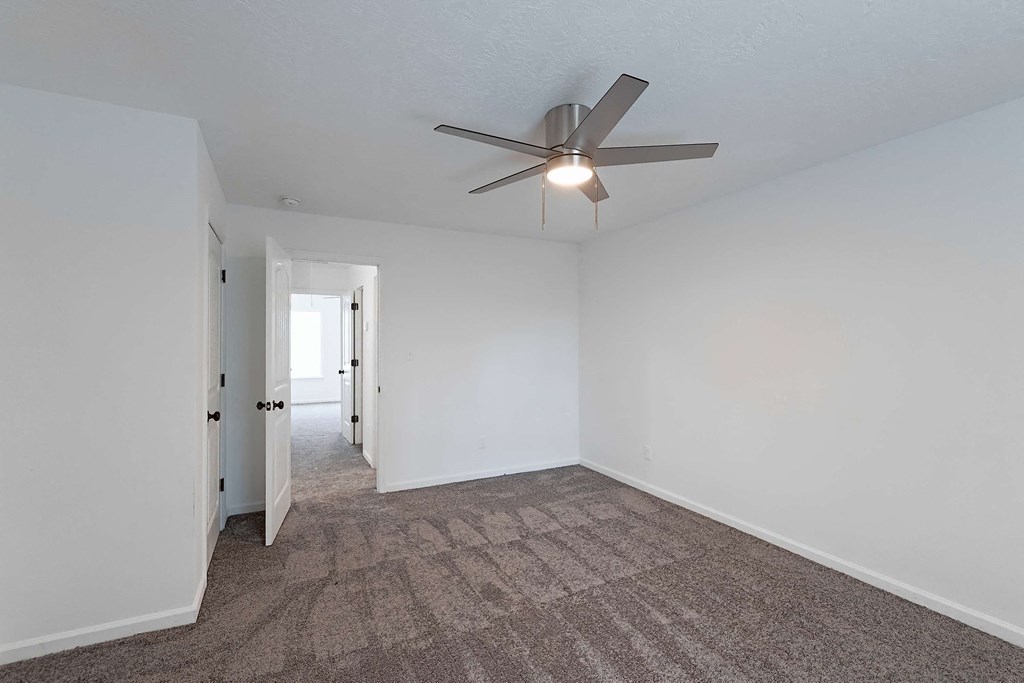 Carpeted bedroom with ceiling fan
