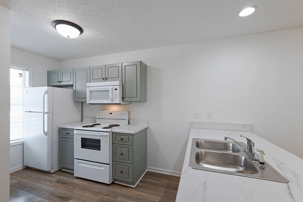 Kitchen area with white appliances at Sterlington Apartments, Georgia