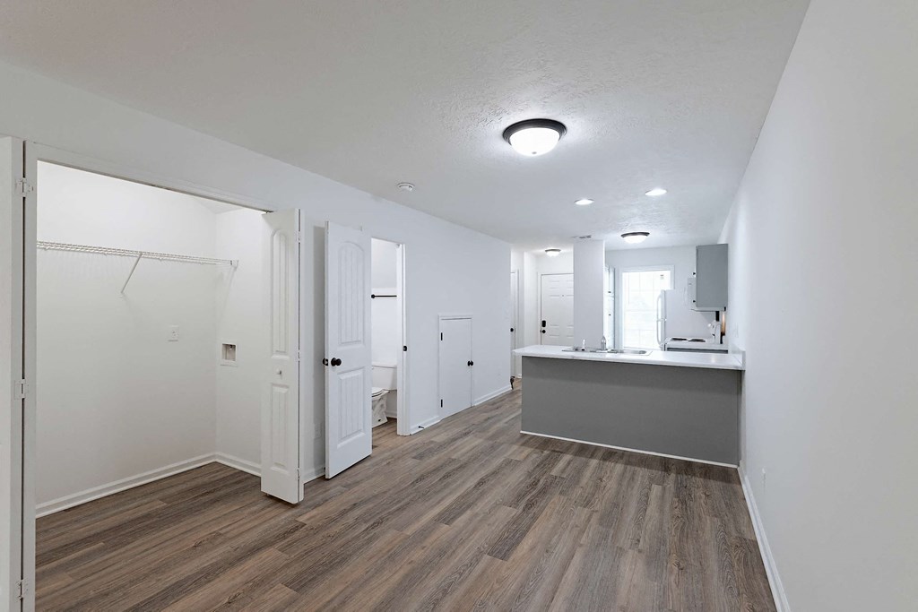 Living room with view of kitchen and washer/dryer closet at Sterlington Apartments, Grovetown, Georgia