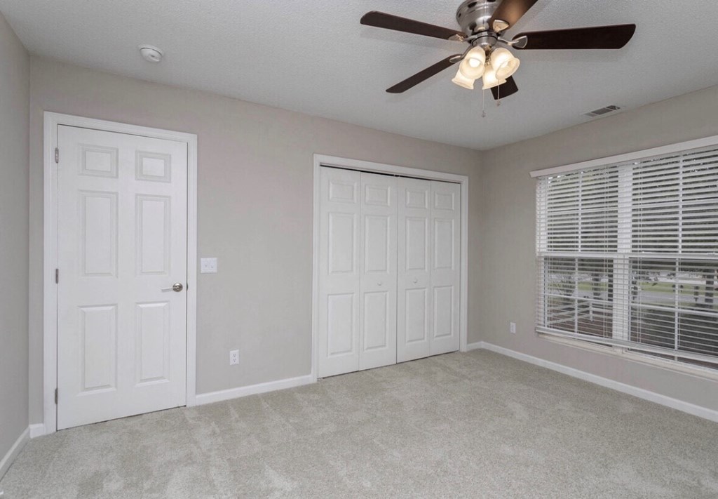 A room with a ceiling fan and two doors at Diamond Townhomes, Beaufort, SC