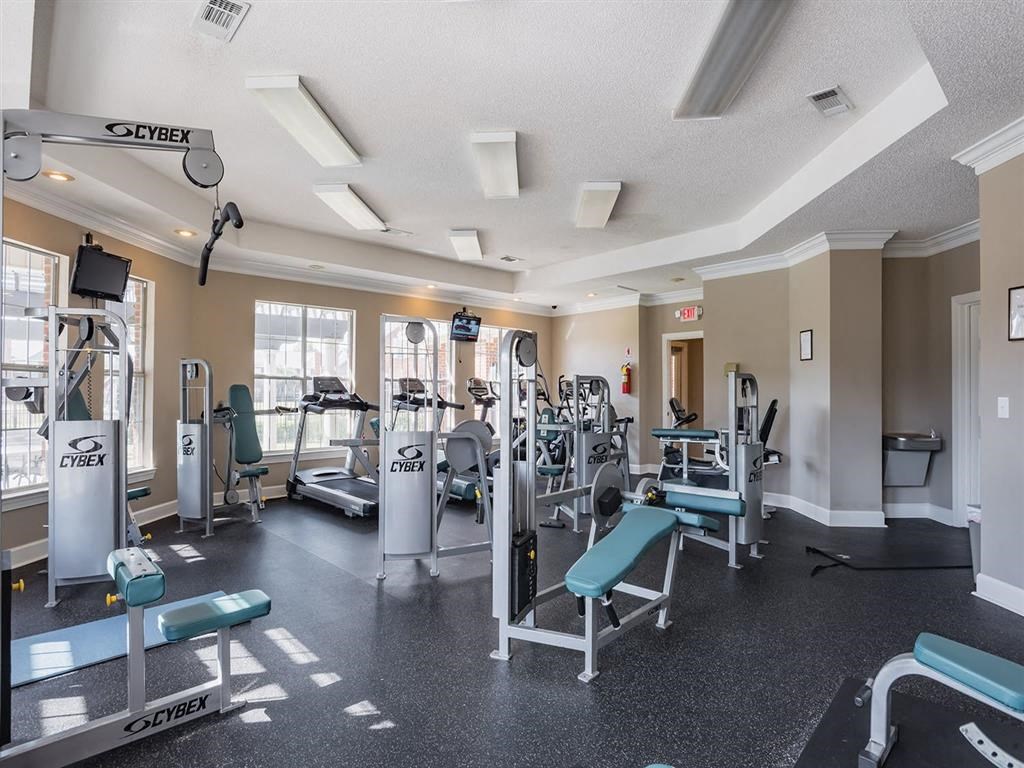 a gym with cardio machines and weights on the floor