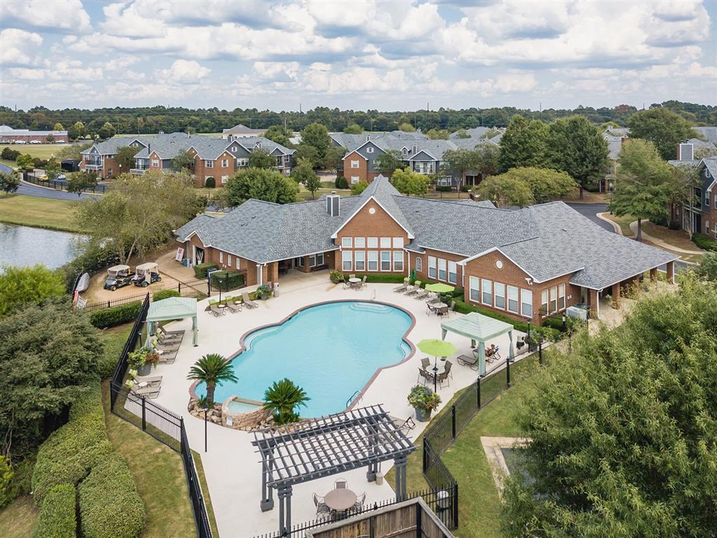 an aerial view of a swimming pool in front of a house