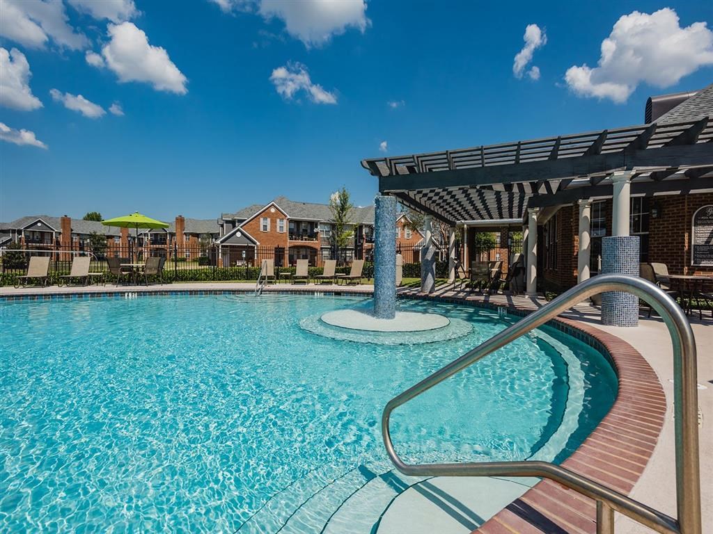 a swimming pool with a pavilion and a blue sky