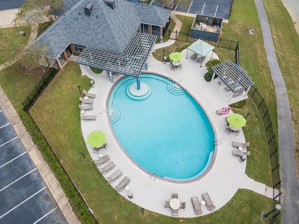 an aerial view of a resort style swimming pool with lounge chairs around it