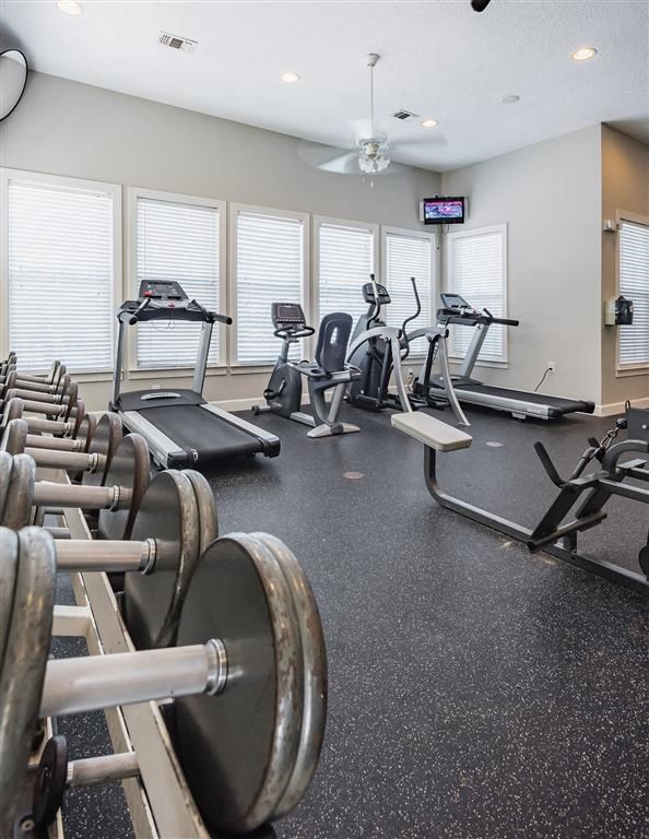 a gym filled with cardio equipment and weights