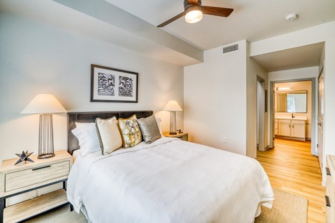 A bedroom with a large bed and a ceiling fan.
