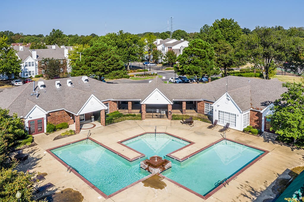 an aerial view of a swimming pool with a building in the background