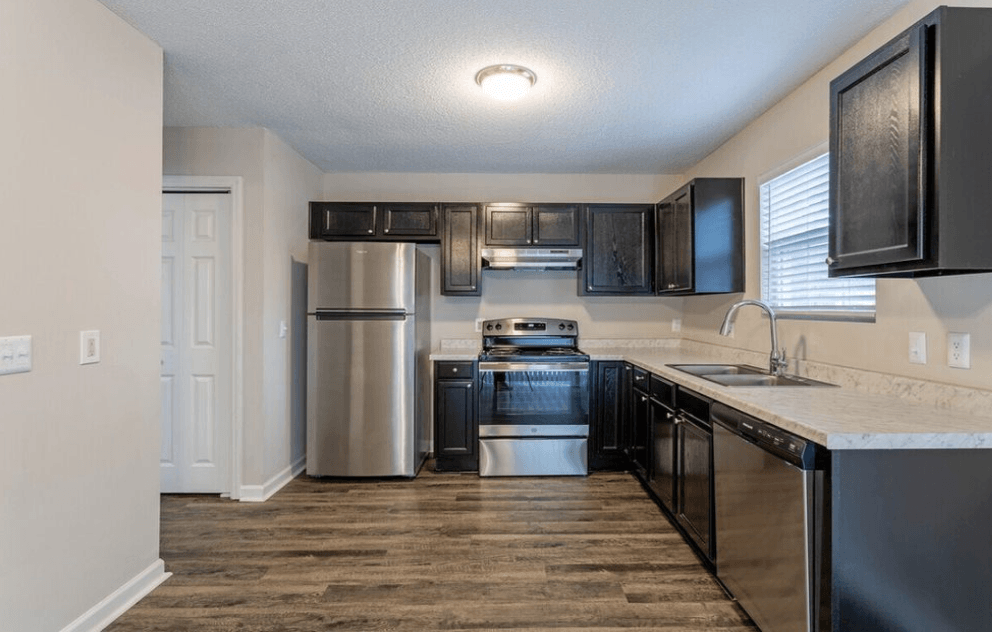 A kitchen with black cabinets and stainless steel appliances at Diamond Townhomes, Beaufort, 29906